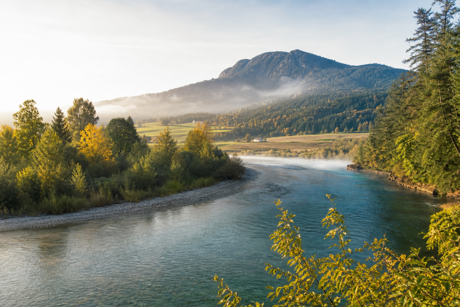Duncan area river bend with clear teal water, trees, valley farmland, and a low mountain hillside